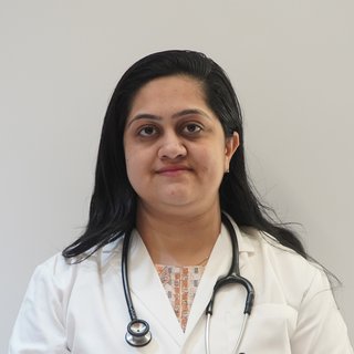 Portrait of Dr. Digita J. Bhati wearing a white coat and stethoscope.