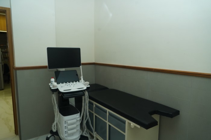 The sonography room, with an ultrasound machine beside a cushioned examination couch.