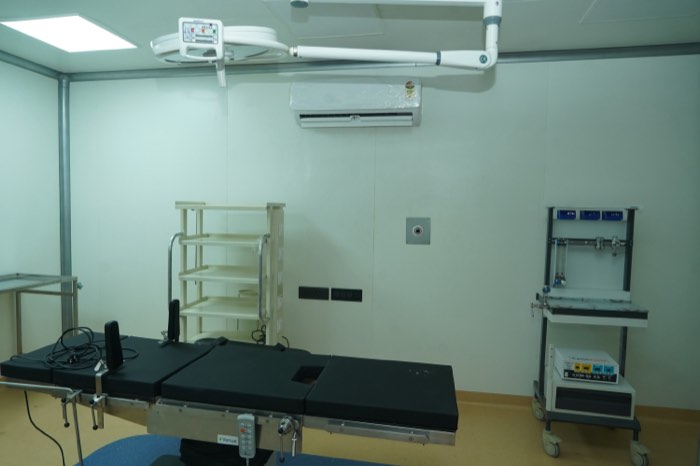 The modular operation theatre: an operating table under a ceiling-mounted surgical light, with an anaesthesia gas panel at the side.